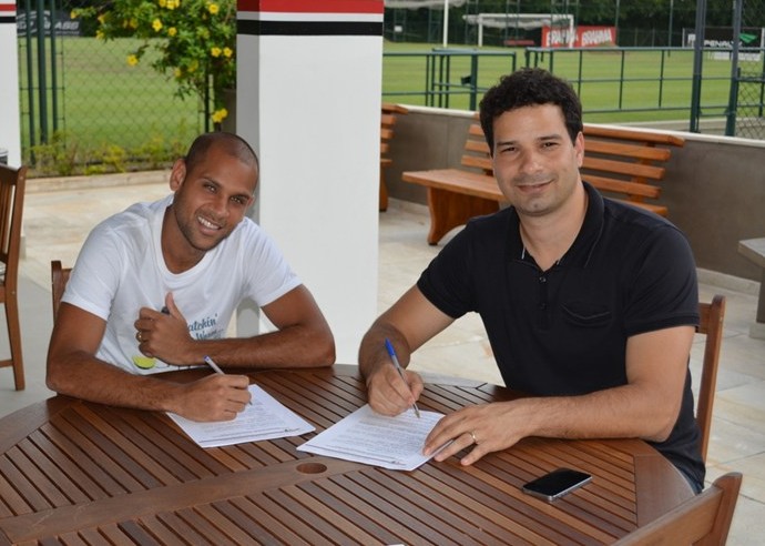 Carlinhos assina contrato ao lado de Gustavo Vieira de Oliveira, dirigente tricolor (Foto: Site Oficial / saopaulofc.net)